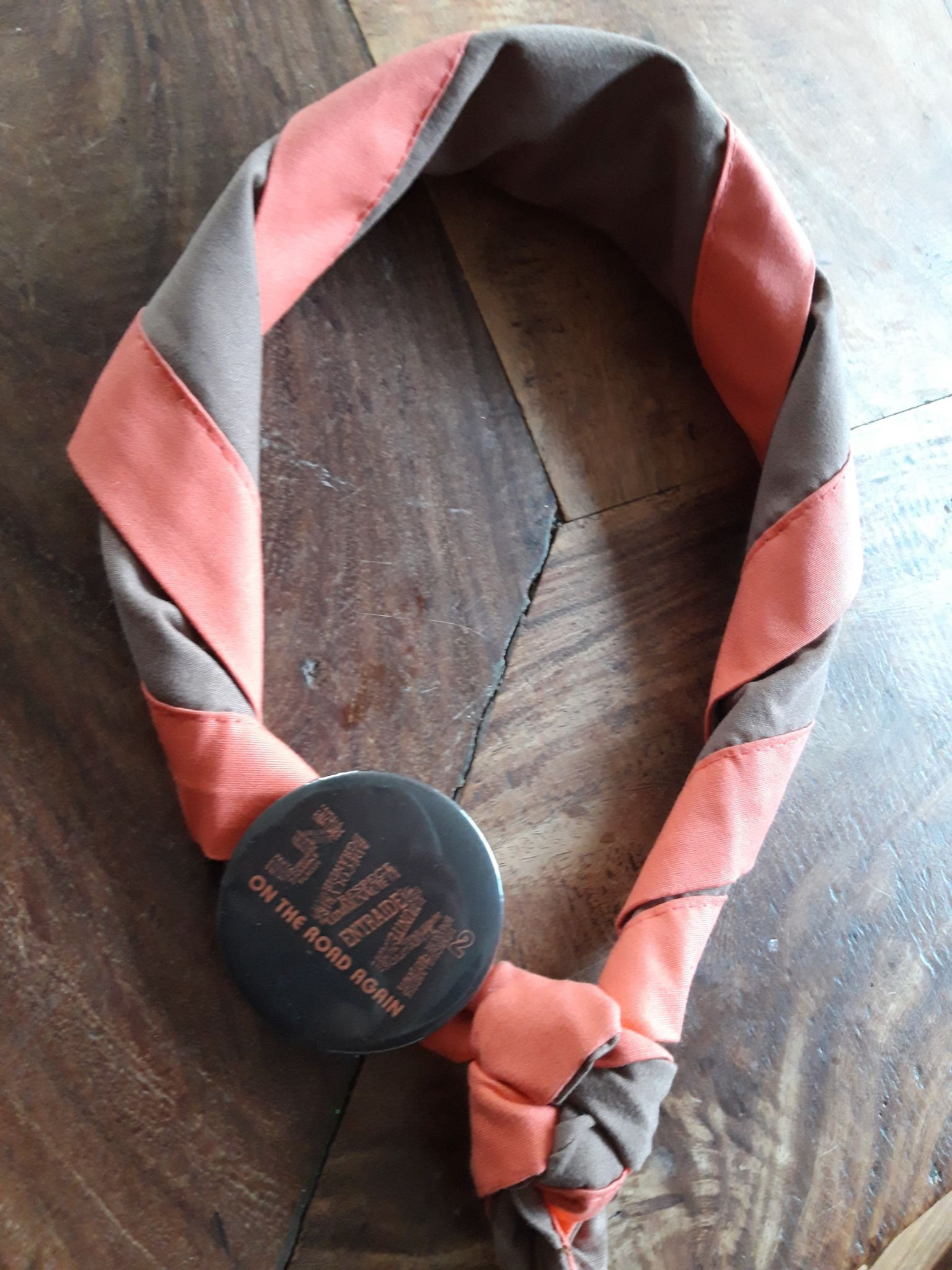 Le foulard de l'unité, brun bordé d'orange